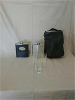 Two flasks with three shot glasses and a cooler