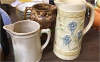 Three large vintage pottery pitchers, one has
