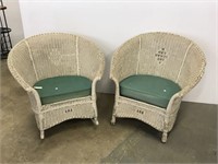 Two white wicker porch chairs