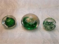 3 green glass paperweights