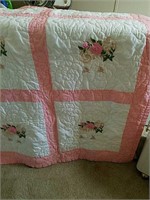 A beautiful pink and white with rose pattern quilt