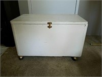 White wooden box on casters with latch on front