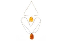 Two natural amber pieces mounted as pendants