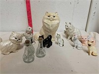 Group of cat statues and glass bottles