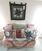 White painted bench, pillows and hanging quilt