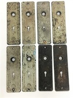 Eight antique door lock plates.