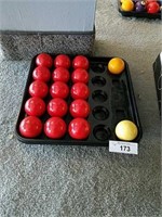 Box of 15 solid red pool balls and 2 cue balls