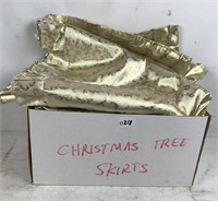 Six gold colored Christmas tree skirts
