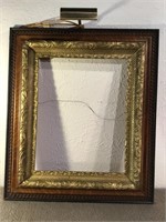 Large antique wood and plaster frame with light.