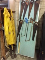 group of saws, pegboard, rain suit, rubber boots