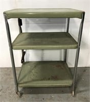 Green metal cart with attached extension cord.