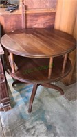 Cherry round drum table with a shelf below has a