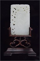 Chinese carved jade plaque raised on a rosewood