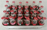 24 Coca-Cola bottles and crate