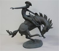 Large bronzed metal sculpture of a cowboy