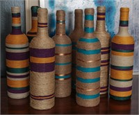 A COLLECTION OF COLORFUL TWINE WRAPPED BOTTLES