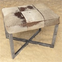 A CONTEMPORARY CHROME STOOL WITH COWHIDE COVER