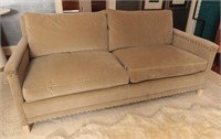 A TWO CUSHION SOFA WITH TACK HEADS