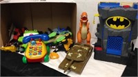 Group of toys includes Batman toy, dinosaurs,