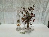 Kerosene lamp and metal vase with flowers