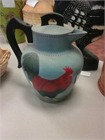 A tea pitcher with a rooster on it