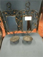 A pair of metal wall hanging candle holders with