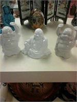 A set of three white Buddha statues