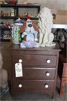 small chest of drawers and cement figures