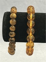 A lot of two stretch bracelets; one is Amber beads