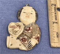 Relief carved buffalo bone pendent of a young orie