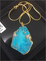 Turquoise pendant wrapped in gold with gold chain