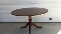 Round walnut tilt-top dining table