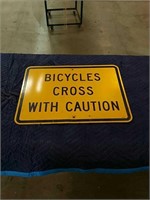 Bicycles cross with caution yellow metal sign