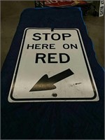 Stop here on red metal sign