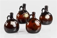 Four Georgian dark amber glass jugs