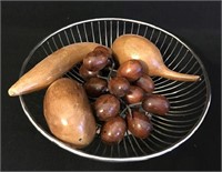 Round wire basket containing carved fruit