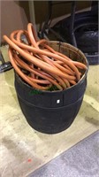 Black wood barrel with a orange air hose, barrel