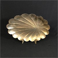 Large metal scalloped dish on display stand.