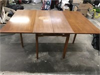 Drop leaf table-top has scratches and scuffs.