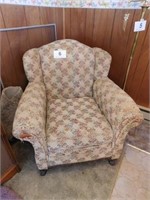 Vintage upholstered chair with wooden claw feet,