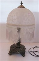 Metal table lamp with glass shade featuring bead