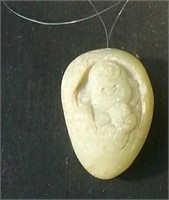 Carved rock with a hole for use as a necklace