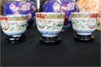 Three Oriental Tea Cups on Wooden Stands
