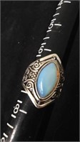 Opalescent gemstone inlaid in silver color band