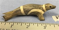 A carved striped seal walrus ivory by Peter Mayac,