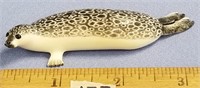 A phenomenal core ivory carving of a spotted seal,
