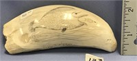 Whale's tooth, scrimshawed with a blow fish eating