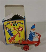 Clown riding scooter wind-up tin toy