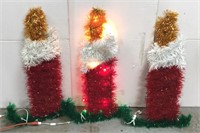 Three lighted outdoor Christmas candles