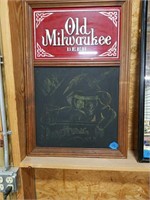 Old Milwaukee beer sign with chalkboard.
